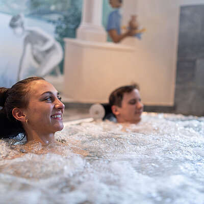 Paar beim Wellnessurlaub im Pool im Hotel Solaria Ischgl